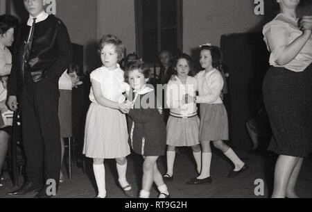 Degli anni Cinquanta, storiche, i bambini ballano insieme a un ricevimento di matrimonio in una chiesa Hall, Inghilterra, Regno Unito. Foto Stock