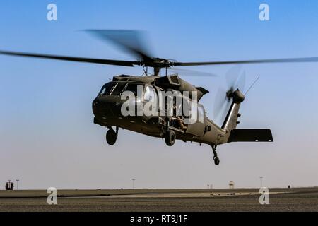 Esercito Nazionale Guardie di decollo in un UH-60 Black Hawk elicottero decollare da Udairi zona di atterraggio, Camp Buehring, Kuwait, 29 gennaio, 2019. Stati Uniti I soldati assegnati a 1st, battaglione, 108th elicottero d'assalto battaglione, Kansas esercito Guardia Nazionale, aviazione fornito sostegno a U.S. Cecchini dell'esercito assegnato alla società di sede, 2° Battaglione, 137Reggimento di Fanteria, 155Armored Brigade Combat Team, Kansas Esercito Nazionale Guardia, durante un'antenna sniper esercizio. Foto Stock