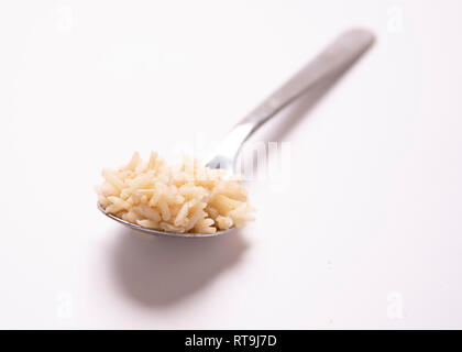 Un cucchiaio di cibo. La porzione di controllo. Riso marrone. Foto Stock