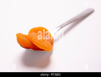 Un cucchiaio di cibo. La porzione di controllo. Albicocche secche. Foto Stock