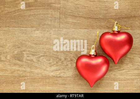 Due cuori rossi su un effetto legno sullo sfondo del pavimento Foto Stock