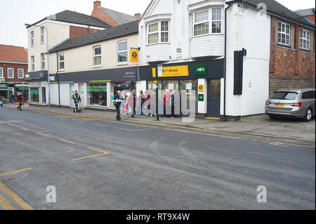 Persone in attesa al di fuori della NFU National Farmers Union shop, Driffield East Yorkshire. Regno Unito, GB. Foto Stock