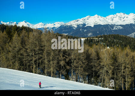 Uno sciatore sulla neve pendii montani. paesaggio con bella foresta conferous e cielo blu. Plan de Corones, Dolomiti, Alto Adige, Italia. Foto Stock