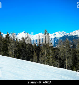 Immagine quadrati vuoti di montagna sciistica pendio di neve paesaggio con bella foresta conferous e cielo blu. Plan de Corones, Dolomiti, Alto Adige, Italia. Foto Stock