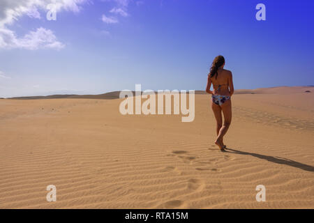 Giovane donna skinny camminando lungo le dune di Maspalomas, Gran Canaria Foto Stock