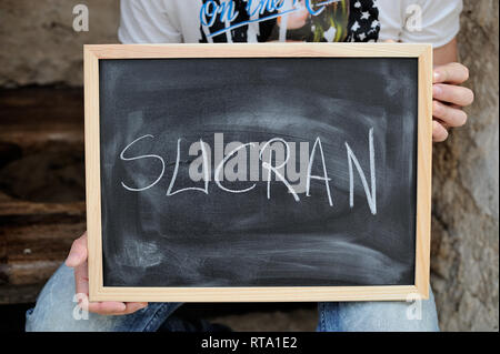 Parola grazie in Arabo scritto su una lavagna nera con gesso bianco Foto Stock