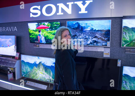 Il 10 febbraio 2019-Buicharest, Romania. Una donna che guarda la TV per acquistare uno. Foto Stock