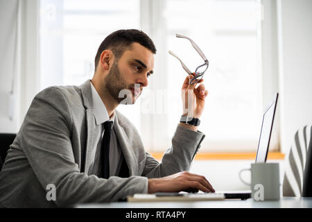 Giovane imprenditore sta lavorando in ufficio. Egli è preoccupato. Foto Stock