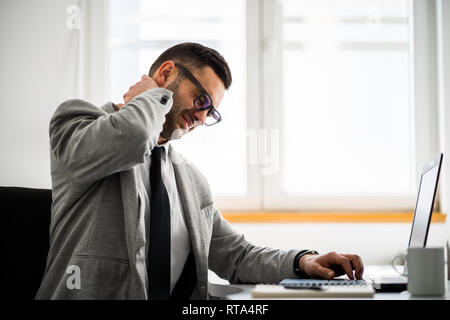 Giovane imprenditore è avere dolore nel suo collo. Foto Stock