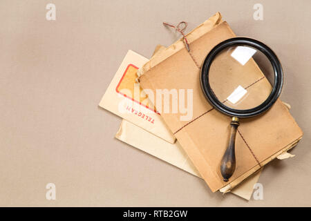 Vintage lente di ingrandimento con un vecchio telegramma e libri Foto Stock
