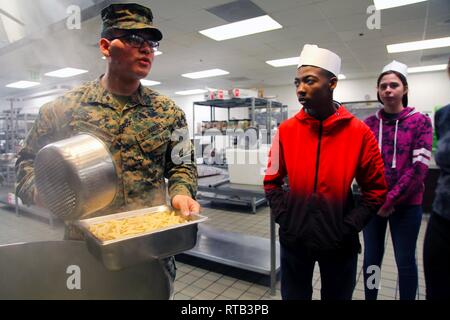 Lancia Cpl. Emiliano Corralejoaguirre mostra Morongo Unified School District agli studenti come pasta è preparata a Phelps Hall dining facility, Marine Corps Air Ground Centro di combattimento, ventinove Palms, California, durante il combattimento Scuola centrale di collegamento 16 del lavoro annuale evento di shadowing, 6 febbraio 2019. Foto Stock