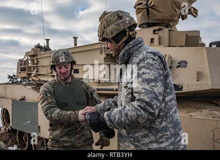 ŚWIĘTOSZÓW, Polonia (feb. 6, 2019) - Vincent "B.J." Lawrence, il comandante in capo dei veterani delle guerre straniere di Stati Uniti, dà una sfida moneta a Sgt. Michael Messersmith, un M1 Abrams serbatoio Gunner con il 1° Stormo, 4 U.S. Reggimento di cavalleria di Fort Riley, Kan. in apprezzamento per il suo lavoro e servizio nell'unità. Come comandante del VFW, Lawrence visitato personalmente i soldati di cavalleria 1-4 mentre mobilitati nel tentativo di comprendere meglio l'ambiente di formazione e le condizioni di vita dei militari di stanza all'estero a sostegno dell'operazione Atlantic risolvere. Foto Stock