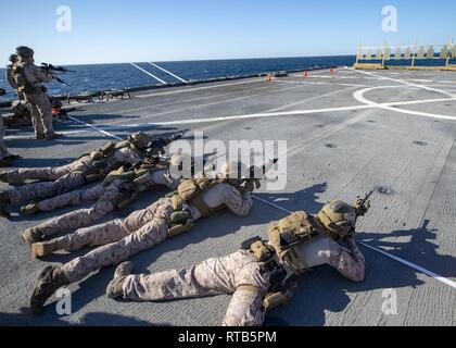 Stati Uniti 5TH FLOTTA AREA DI OPERAZIONI (feb. 7, 2019) Marines assegnato al marittimo forza Raid, 22 Marine Expeditionary Unit (MEU), il fuoco su bersagli durante un esercizio sul ponte di volo dell'Whidbey Island-classe dock anfibio sbarco nave USS Fort McHenry (LSD 43). Fort McHenry è parte dell'anfibio Kearsarge pronto il gruppo e con il ventiduesimo imbarcato MEU, è distribuito negli Stati Uniti Quinta Flotta area di operazioni a sostegno di operazioni navali per garantire stabilità marittimo e la sicurezza nella regione centrale di collegamento del Mediterraneo e del Pacifico attraverso l'Oceano Indiano occidentale e tre Foto Stock