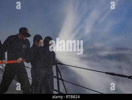 Mare Mediterraneo (feb. 2, 2019) Fire Controlman 2a classe George Wong di San Francisco, California, centro, le pratiche di manipolazione caricato di un tubo flessibile di estinzione mentre riceve la formazione da danni Controlman 3rd Class Aracely Morales di Rialto, California, destra a bordo della San Antonio-classe di trasporto anfibio dock nave USS Arlington (24 LPD), Febbraio 2, 2019. Arlington è su una distribuzione programmata come parte dell'anfibio Kearsarge Gruppo pronto a sostegno della sicurezza marittima, operazioni di risposta alle crisi del teatro e la cooperazione in materia di sicurezza, fornendo nel contempo anche un avanzamento presenza navale. Foto Stock