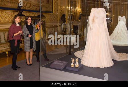 La principessa Eugenie colloqui con senior curator Caroline de Guitaut (sinistra) come ella vista la sua sera abito da sposa, parte di un display del suo matrimonio abiti in una nuova mostra al Castello di Windsor. Foto Stock