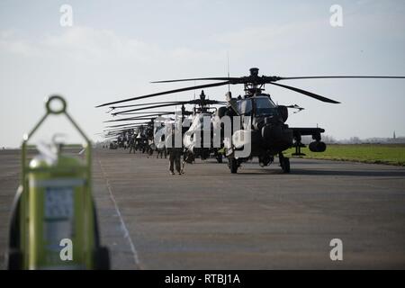 Stati Uniti Esercito personale di terra, assegnato al primo combattimento Brigata Aerea, 1a divisione di fanteria, preparare AH-64 elicotteri Apache per il decollo su Wingene Air Base, Belgio, Febbraio 7, 2019. Wingene Air Base è servita come un intermedio area di sosta prima della 1a combattere la Brigata Aerea distribuisce in Germania, Polonia, Lettonia e Romania per nove mesi al treno con i partner della NATO a sostegno della Atlantic risolvere. Foto Stock