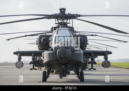 Gli Stati Uniti Esercito equipaggio di un AH-64 elicottero Apache dal primo combattimento Brigata Aerea, 1a divisione di fanteria, preparare i loro aeromobili per il decollo da Wingene Air Base, Belgio, Febbraio 7, 2019. Wingene Air Base è servita come un intermedio area di sosta prima della 1a combattere la Brigata Aerea distribuisce in Germania, Polonia, Lettonia e Romania per nove mesi al treno con i partner della NATO a sostegno della Atlantic risolvere. Foto Stock