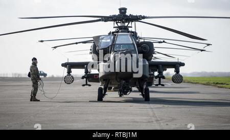 Un U.S. Massa dell'esercito membro di equipaggio del primo combattimento Brigata Aerea, 1a divisione di fanteria, contatti l'equipaggio di un AH-64 elicottero Apache, pronto a lasciare Wingene Air Base, Belgio, Febbraio 7, 2019. Wingene Air Base è servita come un intermedio area di sosta prima della 1a combattere la Brigata Aerea distribuisce in Germania, Polonia, Lettonia e Romania per nove mesi al treno con i partner della NATO a sostegno della Atlantic risolvere. Foto Stock