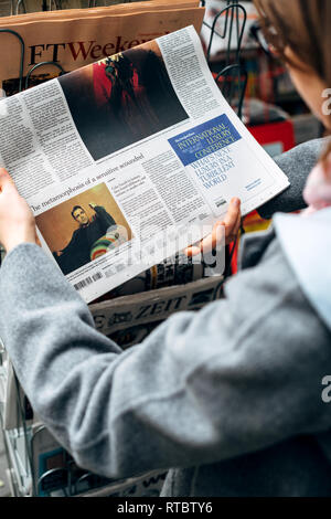 Strasburgo, Francia - 28 OTT 2017: Donna acquisto di lettura del New York Times a premere chiosco composto da Colin Farrell articolo Foto Stock