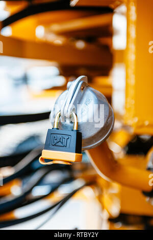 Potente sicuro bloccaggio metallico con il CAT logo sul serbatoio del carburante di un escavatore, trattore trasporto industriale a sito in costruzione Foto Stock