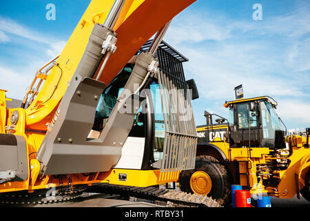 Parigi, Francia - 5 SET 2014: Giallo escavatore Liebherr e Cat trattore parcheggiato su una strada in prossimità del luogo di costruzione in una giornata di sole Foto Stock