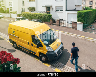 Parigi, Francia - 23 JUN 2017: Courier a camminare verso La Poste giallo van di consegna per la consegna sul pacchetto tempo parcel - vista aerea Foto Stock