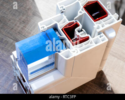 Vista da sopra il taglio del profilo della finestra con metallo, vetro e isolamento esempio rosso con i colori blu e bianchi unità dimostrative per i clienti Foto Stock