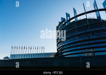 Strasburgo, Francia - 6 Aprile 2018: vista laterale di edificio del Parlamento europeo a Strasburgo con tutti Unione europea bandiere sventolano al sunrise Foto Stock