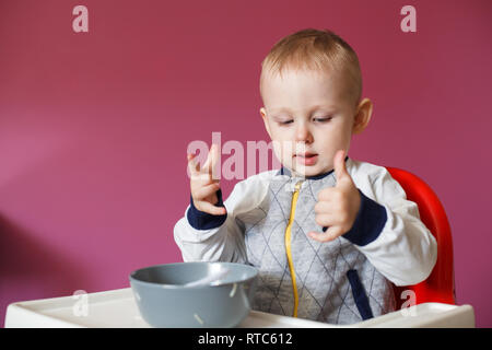 Alimentazione bambino seduto nella sedia alta. Foto Stock