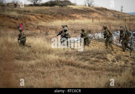 Fanti dal 2 ° brigata corazzate contro la squadra, 1° Divisione di cavalleria smontare il loro combattimento Bradley veicolo in preparazione per entrare e cancellare una trincea durante la combinata live-fire esercizio (CALFEX) Feb 9. Foto Stock