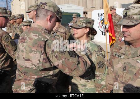 Illinois Esercito Nazionale Guardsman, Sgt. 1. Classe Melissa Kraye, 108th supporto brigata, viene premiato con l'esercito medaglia ottenuta in una cerimonia di premiazione presso il Camp Taji, Iraq nel febbraio 12, 2019. Kraye si distinse durante la pre-treno di mobilitazione. Foto Stock