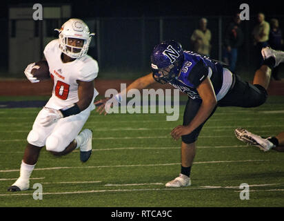 Refugio High School running back Jacobe Avery corre la palla come Navarro High School middle linebacker Ramon Munoz si chiude per il paranco. Foto Stock