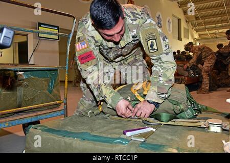 Un U.S. Army Sgt. 1. Classe Javier Pioquinto, paracadutista assegnati al 2° Battaglione, 503rd Reggimento di Fanteria, 173rd Brigata Aerea, prepara 81mm bundle porta per collegare una T-10 parachute presso la base aerea di Aviano, in preparazione per le operazioni di volo su Giulietta zona di caduta, Pordenone, Italia Feb 13, 2019. Il 173rd Brigata aerea è l'U.S. Esercito di risposta di emergenza forza in Europa, in grado di proiettare le forze di pronto ovunque negli Stati Uniti Europeo, Africa Centrale o comandi in aree di responsabilità. Foto Stock