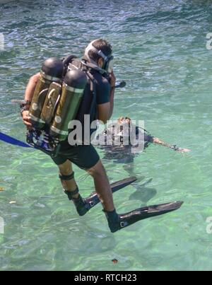 SANTA RITA, Guam (feb. 19, 2019) Navy Diver 2a classe Alec Stuller, un subacqueo di sicurezza assegnato al mobile di immersioni subacquee e di unità di soccorso (MDSU) 1, osserva mentre un dello Sri Lanka navy diver entra in acqua durante il corso di formazione in preparazione per esercitare la cooperazione a galla la prontezza e la formazione (Carati) Sri Lanka 19. Questo pre-allenamento è stato progettato per familiarizzare il di Sri Lanka team con attrezzature e pratiche che portano fino a caso a partire da aprile. Foto Stock