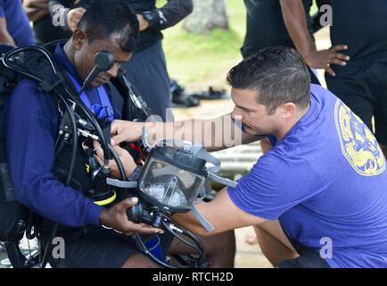 SANTA RITA, Guam (feb. 19, 2019) Navy Diver 1a classe Ryan Guenther, destra 1a classe assegnato subacqueo per immersioni Mobile e unità di soccorso (MDSU) 1, aiuta un dello Sri Lanka navy diver don la sua marcia di immersione durante il corso di formazione in preparazione per esercitare la cooperazione a galla la prontezza e la formazione (Carati) Sri Lanka 19. Questo pre-allenamento è stato progettato per familiarizzare il di Sri Lanka team con attrezzature e pratiche che portano fino a caso a partire da aprile. Foto Stock