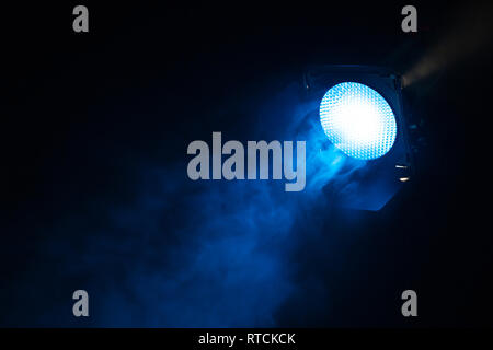 La luce blu con fumo su sfondo scuro. Attrezzature per foto in studio. Foto Stock