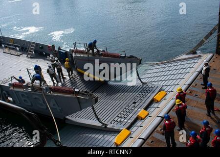 SASEBO, Giappone (feb. 14, 2019) Landing Craft, utilità 1634, dalla base navale di unità di spiaggia (NBU) 7, conduce una porta di poppa il matrimonio con il dock di anfibio sbarco nave USS Germantown (LSD 42) durante un corso di formazione per l'evoluzione. Una porta di poppa matrimonio attrezzatura consente di spostare su on o off la nave senza dover portare il LCU del tutto nella ben coperta. Foto Stock