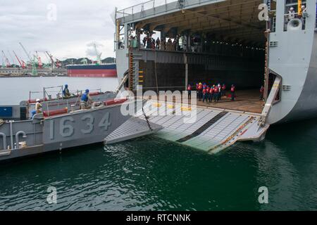 SASEBO, Giappone (feb. 14, 2019) Landing Craft, utilità 1634, dalla base navale di unità di spiaggia (NBU) 7, conduce una porta di poppa il matrimonio con il dock di anfibio sbarco nave USS Germantown (LSD 42) durante un corso di formazione per l'evoluzione. Una porta di poppa matrimonio attrezzatura consente di spostare su on o off la nave senza dover portare il LCU del tutto nella ben coperta. Foto Stock