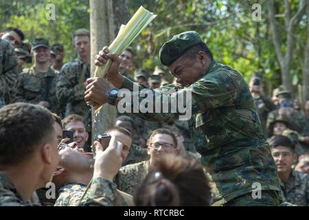 Un Royal Thai Marine spreme acqua da un albero di banane nella bocca di un Marine con il Battaglione Team di atterraggio, 1° Battaglione, 4 Marines, durante la giungla di formazione di sopravvivenza, Esercizio Cobra Gold 19, Camp Ban Chan Khrem, Khao Khitchakut distretto, Thailandia, Feb 15, 2019. Esercizio Cobra Gold dimostra l'impegno del Regno di Tailandia e gli Stati Uniti alla nostra lunga alleanza, promuove partenariati regionali e avanza la sicurezza e la cooperazione nella regione Indo-Pacifico. Il trentunesimo Marine Expeditionary Unit, Marine Corps' solo in modo continuo distribuita MEU, fornisce un ridistribuire Foto Stock