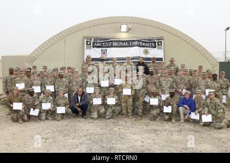 Stati Uniti Gli studenti dell'esercito di Stati Uniti Esercito di segnale di centrale Università a Camp Arifjan, Kuwait posano per una foto di gruppo dopo la laurea, Feb 15, 2019. Tenendo classi impegnativi mentre implementato per consentire agli studenti di prepararsi per la certificazione professionale che li rende e la loro unità più letale per vincere la nostra nazione le guerre, poi tornare a casa in modo sicuro; parte dell'esercito della strategia di modernizzazione. Foto Stock