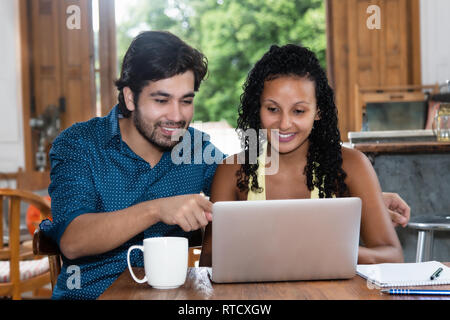 Giovani Latinoamericani amore giovane prenotazione hotel all interno del computer a casa Foto Stock