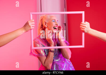 Timida donna anziana dimostrando il suo sorriso sincero Foto Stock