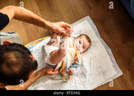 Padre cambiando la sua figlia pannolino sporco. Foto Stock