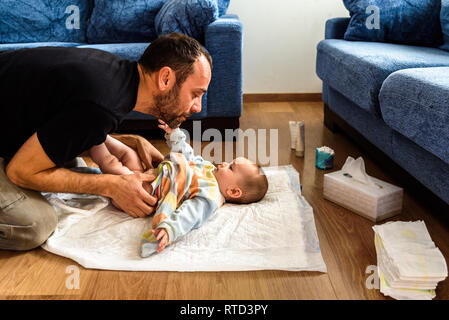 Padre cambiando la sua figlia pannolino sporco. Foto Stock