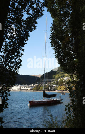 La Coppa America di Vela Barca NZL14 da 1992 ormeggiata nel porto di Queenstown sul lago Wakatipu, Nuova Zelanda Isola del Sud al tramonto con spiaggia di Queenstown. Foto Stock