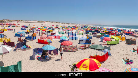 Spiaggia affollata di frangiventi e ombrelloni, Praia da Barra, Aveiro, Portogallo Foto Stock