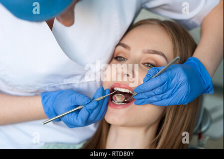 Medico dentista esaminando una denti del paziente. Dental Clinic. Foto Stock