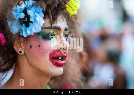 RIO DE JANEIRO - Febbraio 25, 2017: un uomo brasiliano festeggia il carnevale con un costume di parodia con Colorati luminosamente trucco in corrispondenza di una parte di strada. Foto Stock