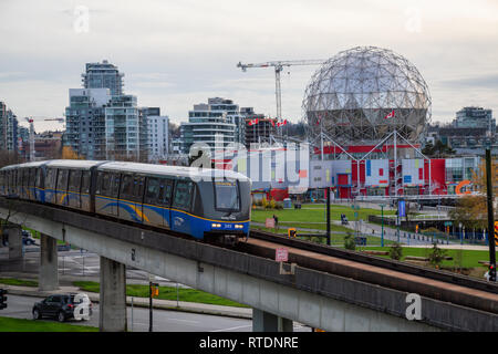Il centro di Vancouver, British Columbia, Canada - 29 Novembre 2018: lo Skytrain che passa nella città moderna durante una sera Nuvoloso. Foto Stock