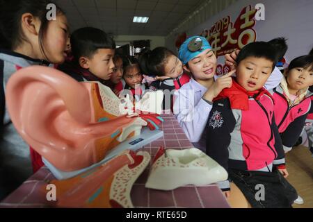 Lianyungang, cinese della provincia di Jiangsu. 1 Mar, 2019. Un medico introduce orecchio conoscenza di cura per i bambini in un asilo nido nella contea di Donghai in Lianyungang, est cinese della provincia di Jiangsu, 1 marzo 2019. Della Cina di orecchio nazionale cura giorno cade il 3 marzo. Credito: Zhang Kaihu/Xinhua/Alamy Live News Foto Stock